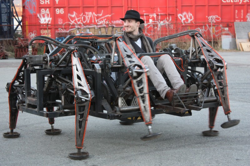 Picture of Mr. Christie sitting in a alarge eight-legged robotic walking machine